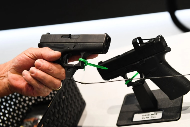 Un asistente sostiene una pistola Glock durante la reunión anual de la NRA en el Centro de Convenciones George R. Brown, en Houston, el 28 de mayo de 2022.