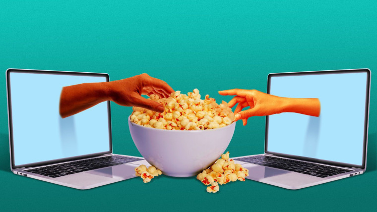 Una mano sale de una pantalla de computadora para agarrar palomitas/choclo de un recipiente en representación de los estrenos de películas en plataformas de streaming