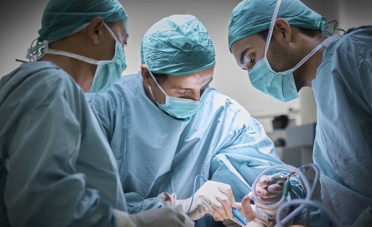Cirujanos plásticos operando a una paciente en una imagen de archivo.
