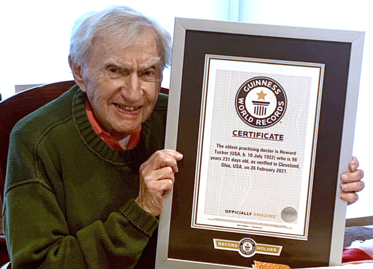Tucker holds his Guinness World Records certificate recognizing him as the world's oldest practicing doctor.