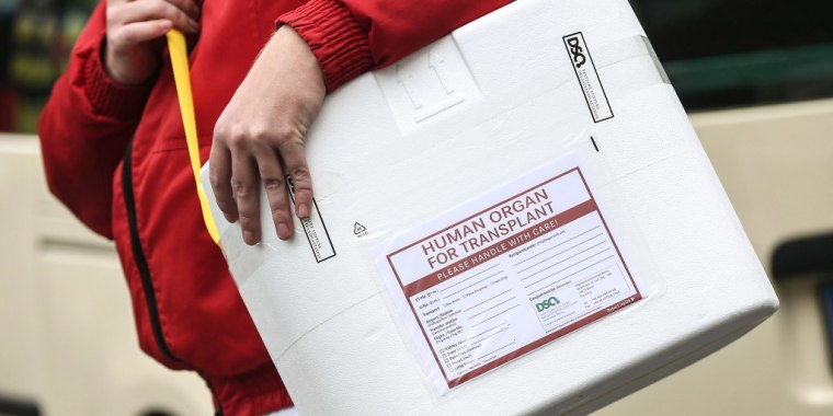 Una persona lleva una caja para transportar un órgano recién donado.