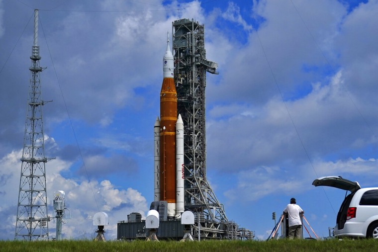Fotógrafos colocan cámaras remotas cerca del cohete de la misión Artemis I en el Centro Espacial Kennedy, el viernes 26 de agosto de 2022, en Cabo Cañaveral, Florida.