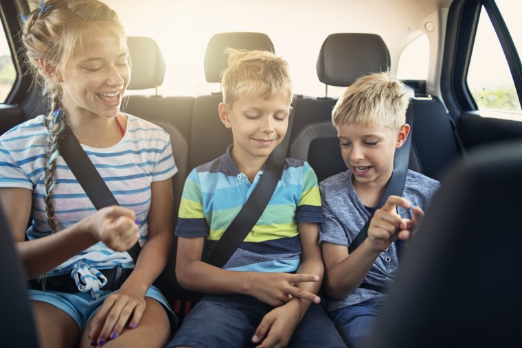 Kids playing games in car during road trip