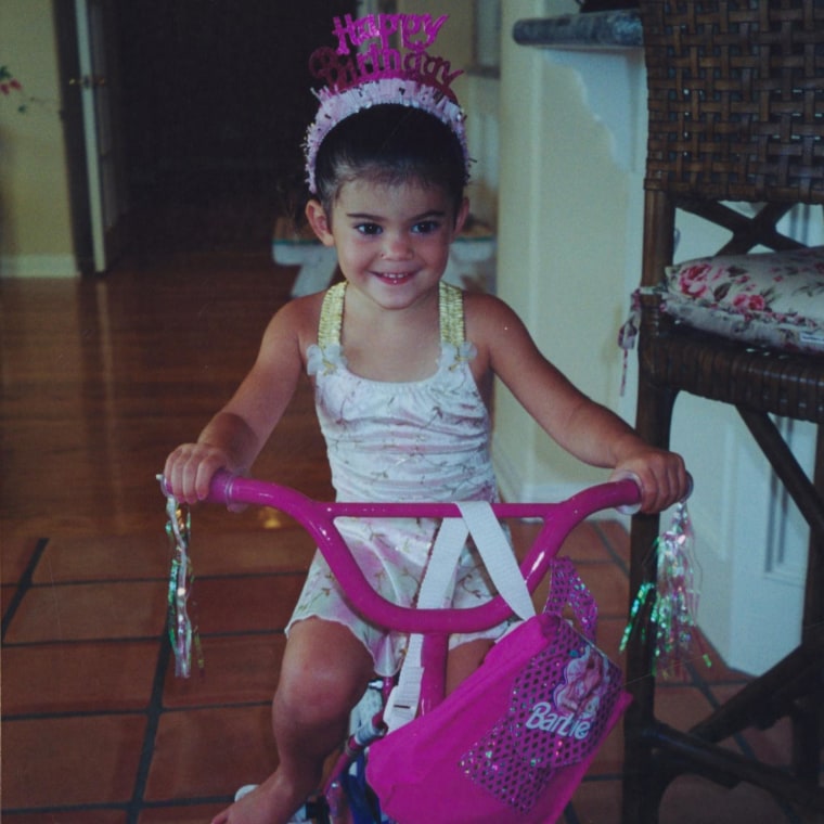 Kylie Jenner niña y jugando con una bicicleta.