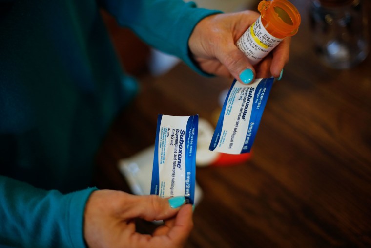 A woman holds a prescription for Suboxone.