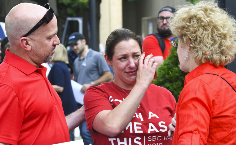 Jules Woodson, centro, es consolada por su novio Ben Smith, izquierda, y Christa Brown durante una manifestación frente a la reunión anual de la Convención Bautista del Sur en Birmingham, en junio de 2019, en la que compartió entre lágrimas que fue abusada sexualmente por un ministro bautista del sur.