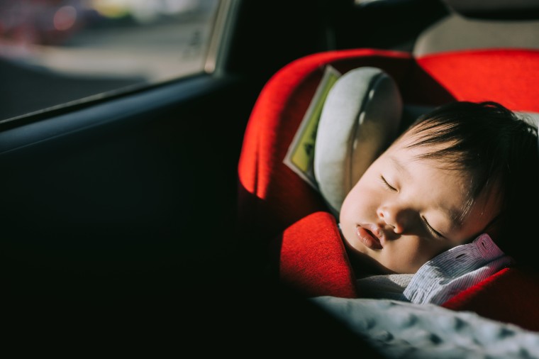Portrait of baby sleeping in carseat.