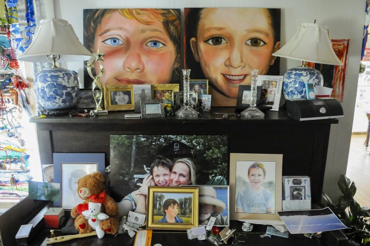 Scarlett Lewis' painted portraits of her two sons, J.T., left, and Jesse sit atop a piano in her living room.