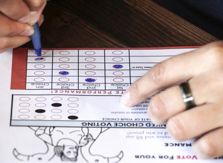 A person completing a ballot in a mock election at Cafecito Bonito in Anchorage where people ranked the performances by drag performers, on July 28, 2022.