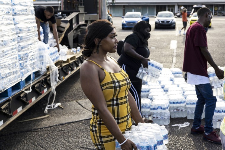 A hands out cases of bottled water