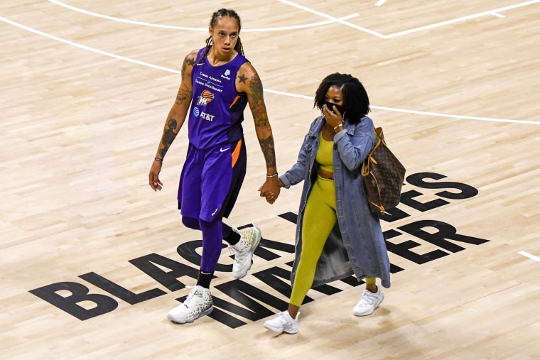 Brittney Griner holds her wife Cherelle Watson's hand after defeating the Dallas Wings on August 10, 2020 in Palmetto, Fla.
