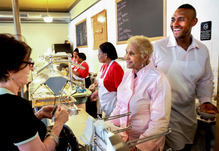 Image:A customer picks up food from Sweetie Pie's owner Robbie Montgomery, center, and Montgomery's son James Timothy Norman, right, at Sweetie Pie's in St. Louis on April 19, 2011.