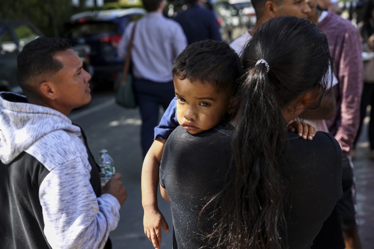 Image: A mother and child wait outside of St. Andrew's Parrish House where Venezuelan migrants were fed lunch with donated food from the community on Sept. 15, 2022 in Martha's Vineyard.