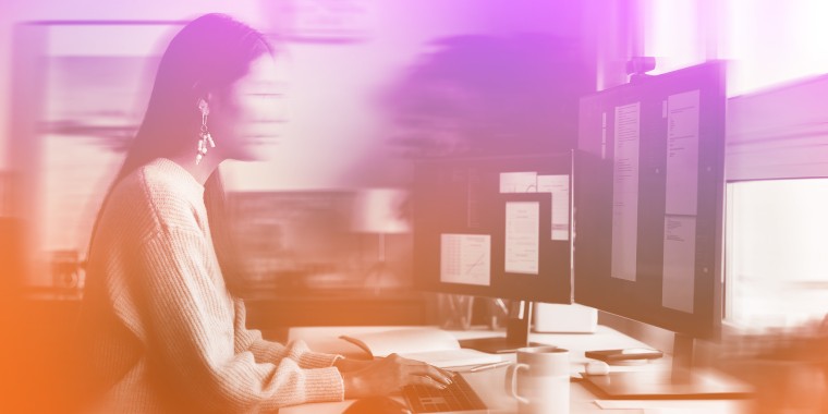 Photo illustration: Blurry image of a women at her work desk.