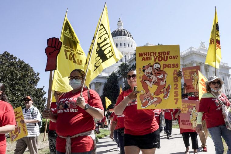 Fast food workers and their supporters march past the state Capitol calling on passage of a bill to provide increased power to fast-food workers in Sacramento, Calif., on Aug. 16, 2022.