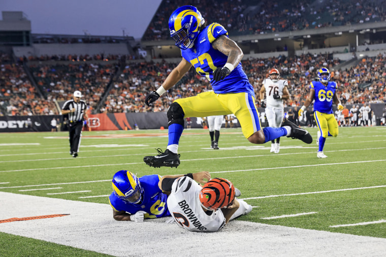 Jake Browning #6 of the Cincinnati Bengals is pushed out of bounds by Grant Haley #36 and Anthony Hines III #57 of the Los Angeles Rams in the fourth quarter on Aug. 27, 2022, in Cincinnati.