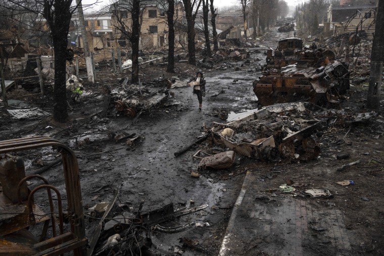 A woman walks on April 3 amid the devastation in the streets of Bucha, on the outskirts of Kiev.