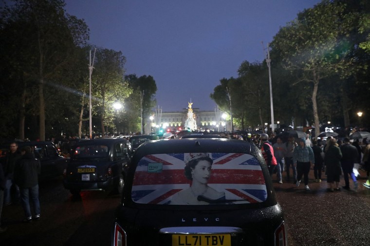 Image: A taxi weaves through crowds of well-wishers on The Mall as people gather outside Buckingham Palace on Thursday.