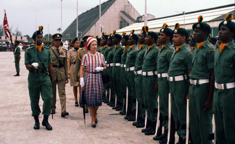 Image: Queen Elizabeth ll inspects an  honor guard as she arrives in Barbados on Oct. 31, 1977.