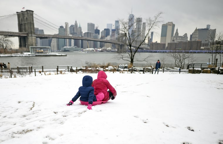 Children slide on a snow-covered hill in Brooklyn, N.Y., in 2019.