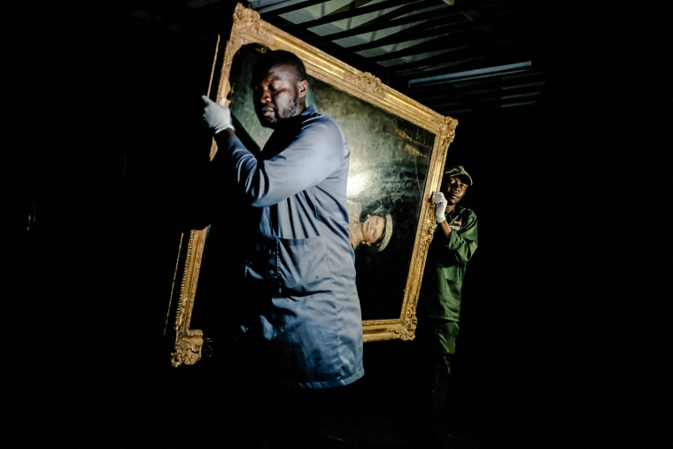 Staff carry a portrait of Queen Elizabeth II, held in storage, as part of the permanent collection of the Zimbabwe National Art Gallery in Harare, Sept. 9 2022.
