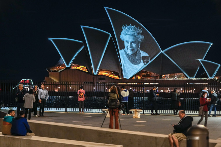 People watch as the Sydney Opera House is illuminated in honor of Queen Elizabeth II in Sydney on Sept. 9, 2022.