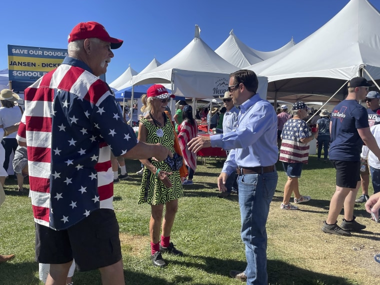 Nevada Republican Senate candidate Adam Laxalt, right, takes photos with supporters during the seventh annual Basque Fry at the Corley Ranch on Saturday, August 13, 2022, outside Gardnerville, Nevada.