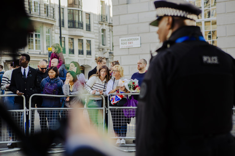 Members of the public wait outside St. James's Palace in central London. 