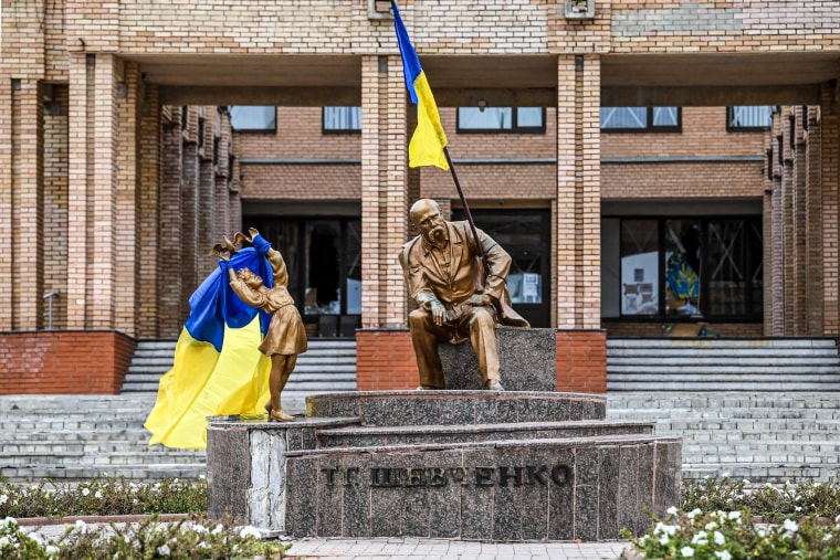 Ukrainian flags placed on statues in a square in Balakliya, Kharkiv region of Ukraine on Sept. 10, 2022.