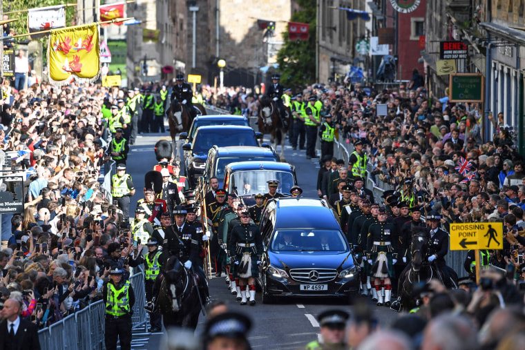 Image: Members of the public gather to watch the procession of Queen Elizabeth II's coffin, from the Palace of Holyroodhouse to St Giles Cathedral, on the Royal Mile on Sept. 12, 2022, where Queen Elizabeth II will lie at rest.