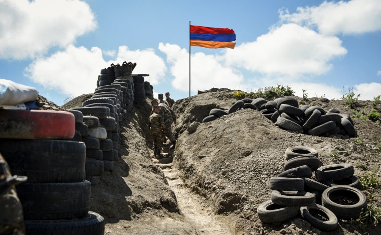 Soldiers walk in a trench at a border check point between Armenia and Azerbaijan near the village of Sotk, Armenia, on June 18, 2021.