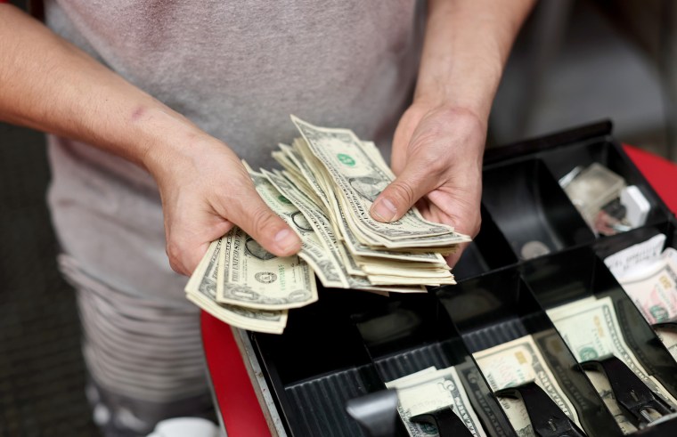 A person sorts the money in the cash register