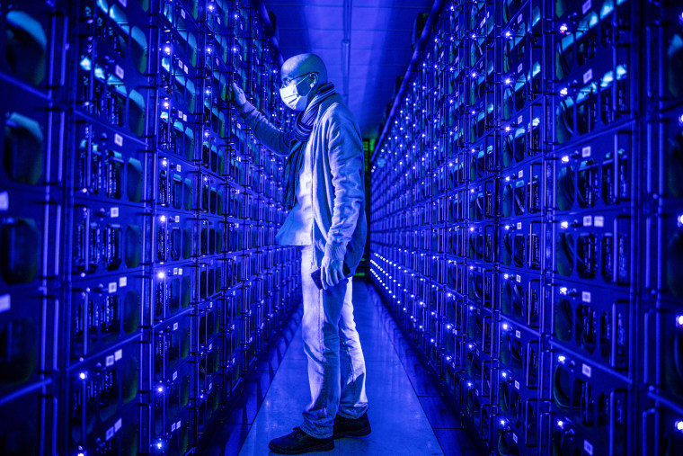 An employee inspects mining rigs mining the Ethereum and Zilliqa cryptocurrencies at the Evobits crypto farm in Cluj-Napoca, Romania, on  Jan. 22, 2021.