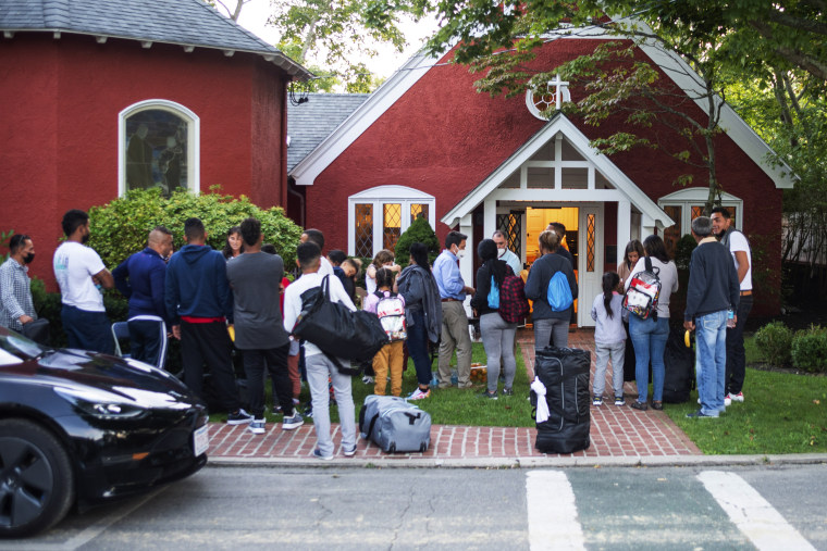 Immigrants gather with their belongings outside St. Andrews Episcopal Church in Edgartown, Mass., on Martha's Vineyard, on Sept. 14.