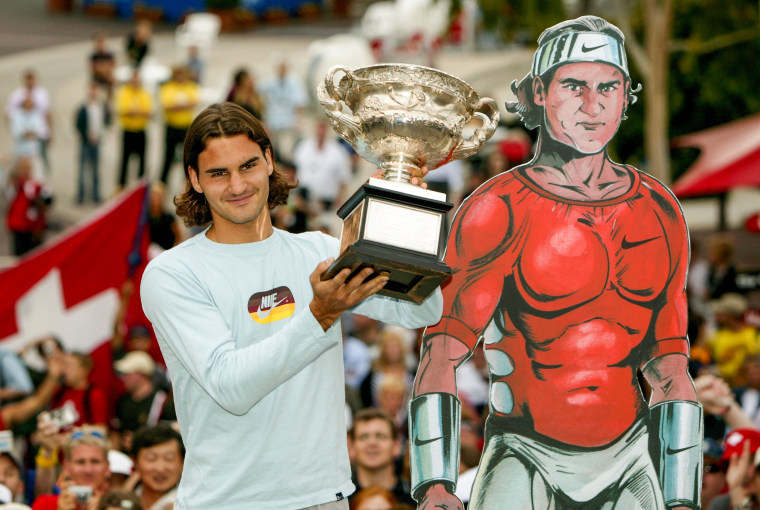 Roger Federer holds up the trophy, next to a cardboard cutout of him, after winning the Australian Open in Melbourne, on Feb. 1, 2004.