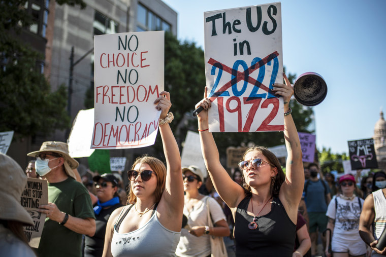 Demonstrators march with signs during a rally for abortion rights