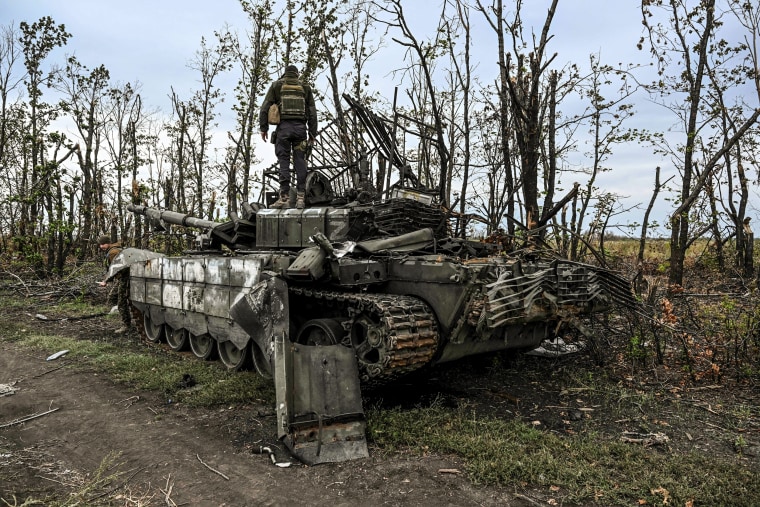 Image: A Ukrainian soldier standing atop an abandoned Russian tank near a village on the outskirts of Izyum, Kharkiv Region, eastern Ukraine on Sept. 11, 2022.