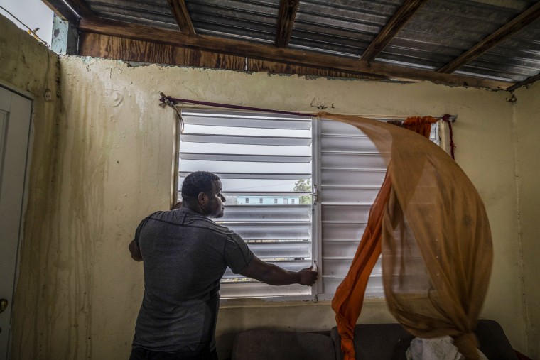 Nelson Cirino secures the windows of his home as the winds of Hurricane Fiona blow in Loiza, Puerto Rico, on Sept. 18, 2022.