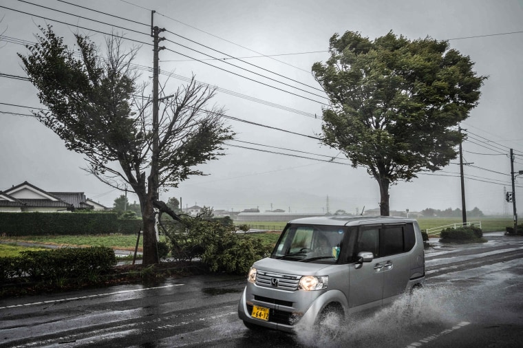 Image: A car passes a fallen tree as Typhoon Nanmadol approaches in Izumi, Kagoshima prefecture on Sept. 18, 2022.