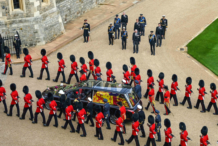 Image: The Royal Family stand by as Grenadier Guards escort the coffin as the Procession of the coffin of Queen Elizabeth II, aboard the State Hearse, travels inside Windsor Castle on Sept. 19, 2022, ahead of the Committal Service for Britain's Queen Elizabeth II.