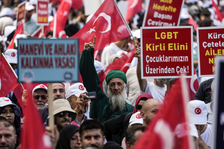 Turkish demonstrators hold banners that reads "Law for the development of the spirit and moral" and "LGBT, remove your dirty hand from our children" during a anti-LGBTQ protest in the Fatih district of Istanbul on Sept. 18, 2022.