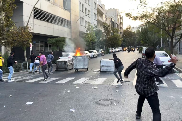 Protesters in Tehran throw stones at police during demonstrations Tuesday over the death of a young woman who had been detained for violating the country's conservative dress code.