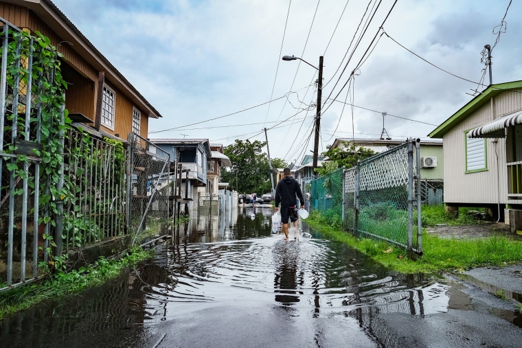 A man walks down a flooded street in the Juana Matos neighborhood of Catano, Puerto Rico on Monday after the passage of Hurricane Fiona.