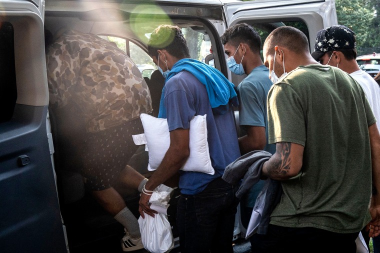 Migrants from Venezuela, who boarded a bus in Texas, wait to be transported to a local church by volunteers after being dropped off outside the residence of Vice President Kamala Harris in Washington on Sept. 15, 2022.
