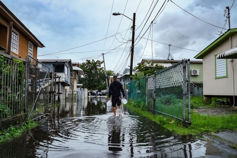 A man walks down a flooded street