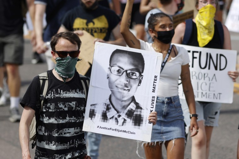 A demonstrator carries an image of Elijah McClain