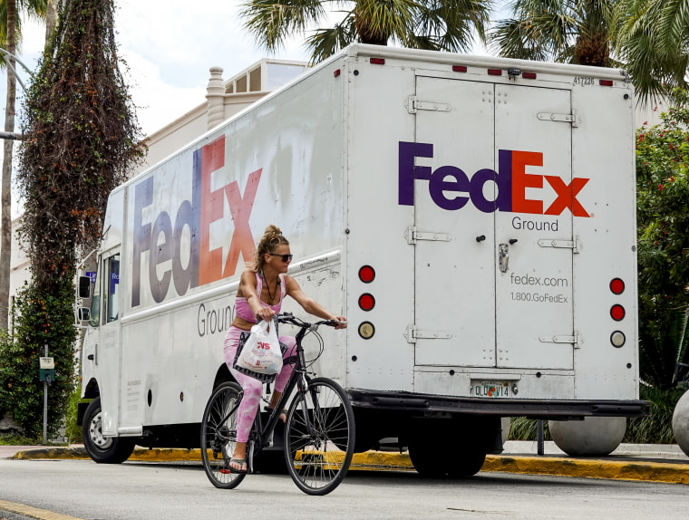 A bicyclist rides past a FedEx truck on Sept. 16, 2022 in Miami Beach, Fla.