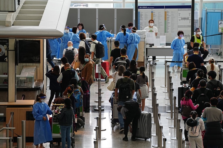 Passengers arriving at Hong Kong International Airport line up for buses heading to quarantine hotels on Friday.