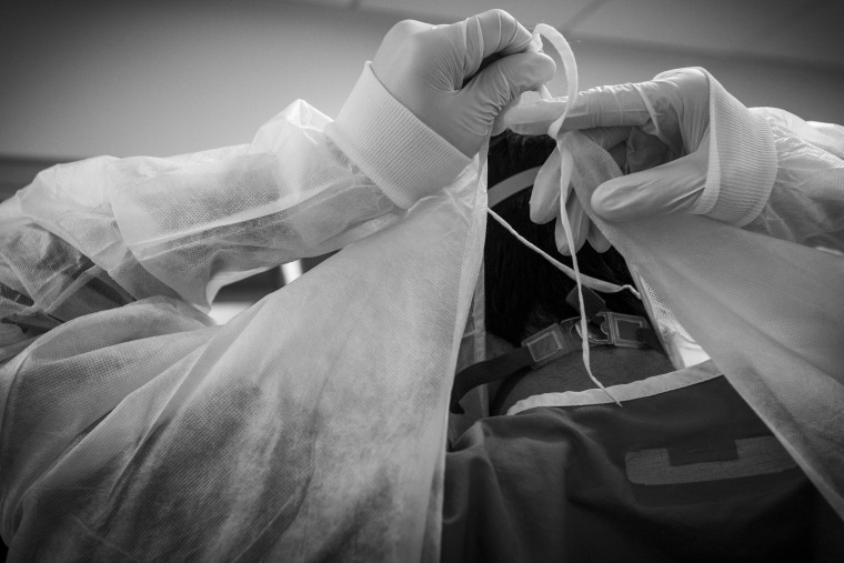 A doctor ties on his isolation gown before assisting a Covid-19 positive patient in the ICU at Martin Luther King, Jr., Community Hospital in Los Angeles on April 18, 2020.