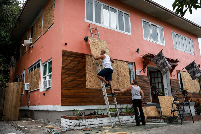 Image: Edward Montgomery and an apartment building as they prepare for the possible arrival of Hurricane Ian
